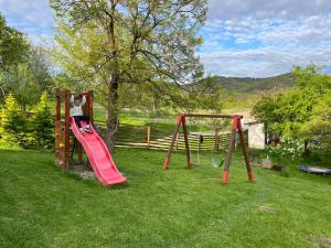 two children playing on a swing set in a yard at Deleni Retreat - Casa Sitaru in Deleni
