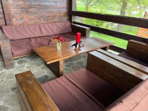 a room with a table and a bench with a candle at Deleni Retreat - Casa Sitaru 