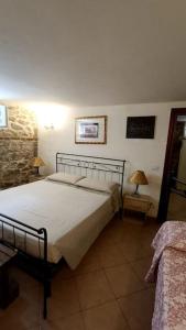 ein Schlafzimmer mit einem Bett, zwei Lampen und einem Sofa in der Unterkunft Taverna abitazione a 15 km da Firenze in Prato