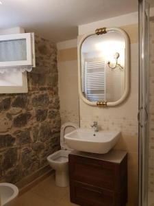 y baño con lavabo, aseo y espejo. en Taverna abitazione a 15 km da Firenze, en Prato