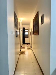 a hallway with white walls and a tile floor at Serene Abodes in Stone Town