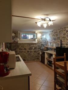 a kitchen with a ceiling fan and a stone wall at Taverna abitazione a 15 km da Firenze in Prato