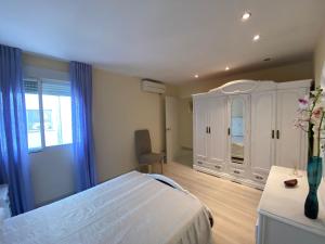 a bedroom with a bed and a cabinet and a window at Corazón del mar in Peniscola