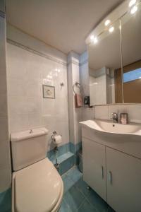 uma casa de banho com um WC branco e um lavatório. em Your Home by the Sea for 3 in Xylokastro em Xylokastron