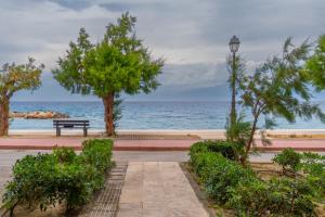 a bench and a street light next to the ocean at Your Home by the Sea for 3 in Xylokastro in Xylokastron