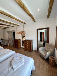sypialnia z 2 łóżkami, krzesłem i lustrem w obiekcie El Amparo w mieście Alhama de Granada
