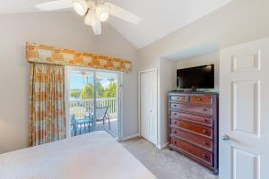 a bedroom with a bed and a dresser with a television at C est la Vie in Duck Key