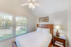 a bedroom with a bed with a ceiling fan and a window at C est la Vie in Duck Key