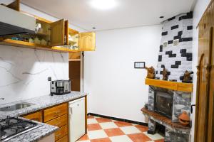 a kitchen with a stove and a fireplace at Salam appartement in Azrou