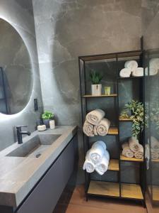 a bathroom with a sink and a shelf with towels at Villa Onari in Alexandroupoli