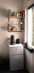 a kitchen with a stove and a shelf with dishes at B & B De Rode Beuk in Hilvarenbeek +9 photos