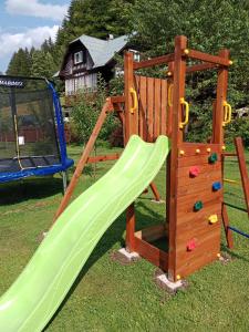 a wooden playground with a slide and a climbing frame at Apartmány Petronela in Makov