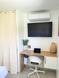 Cette chambre comprend un bureau avec une télévision et une chaise. dans l'établissement Chambre simple climatisée - Proche Tram & Centre, à Montpellier