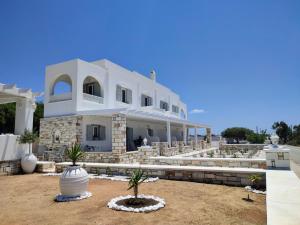 a large white building with palm trees in front of it at Sea and Salt Naxos 3 in Kastraki