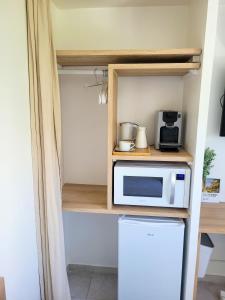 a small kitchen with a microwave and a refrigerator at Chambre simple climatisée - Proche Tram & Centre in Montpellier