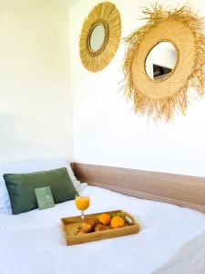 モンペリエにあるChambre simple climatisée - Proche Tram & Centreのベッドの上にオレンジとオレンジジュースを1杯用意しています。