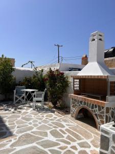 a stone patio with a fireplace and a table at Gala Loft Traditional Stone House in Galanado