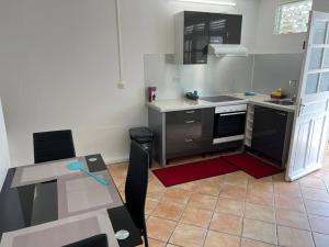 - une petite cuisine avec une table et un comptoir dans l'établissement Appartement cosy et bien situé, à Fort-de-France