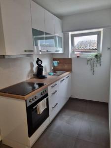 a kitchen with a stove and a sink and a window at ~Ferienwohnung Sandhausen / HD~ in Sandhausen
