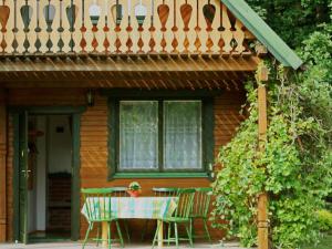 a table and chairs in front of a house at Zielony Domek in Ruciane-Nida