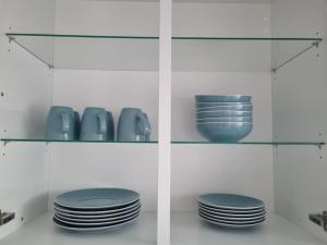 a shelf with plates and vases on it at ~Ferienwohnung Sandhausen / HD~ in Sandhausen