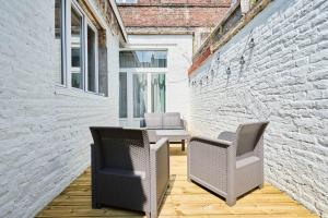 - une terrasse avec 2 chaises et une table dans un bâtiment dans l'établissement Locations Tourcoing - Le Concorde, à Roubaix
