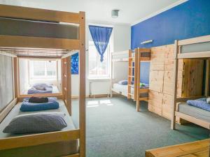 a room with three bunk beds and a blue wall at Cinnamon Sally Backpackers Hostel in Riga