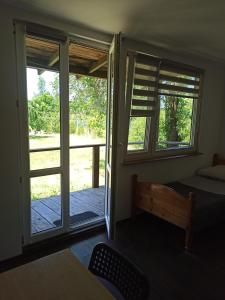 シフィブノにあるZakątek Turystyのベッドルーム1室(ベッド1台付)、スライド式ガラスドアが備わります。