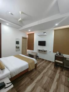 a bedroom with a bed and a desk and a tv at Pink Vista Hotel in Jaipur