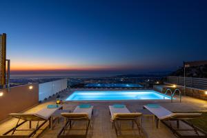 a pool on the roof of a building at night at Villa Nektar with private ecologic pool and amazing view! in Kondópoula