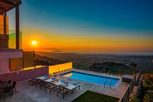 a villa with a swimming pool and a sunset at Villa Nektar with private ecologic pool and amazing view! in Kondópoula