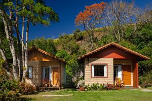 a small house in the woods with trees at Chalé Flores e Amores in Visconde De Maua