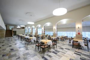 a dining room with tables and chairs and windows at International House of Journalists Resort in Golden Sands