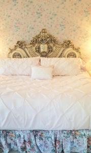 Una cama blanca con cabecero dorado en un dormitorio en French Provincial King Room, en Andes