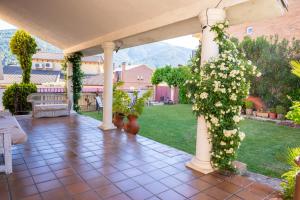 a pergola with white flowers on a patio at Yedrada Alojamientos in La Adrada