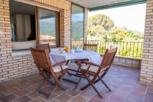 einen Tisch und Stühle auf einer Terrasse in der Unterkunft Yedrada Alojamientos in La Adrada