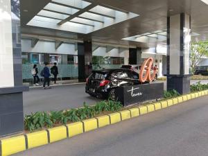 a black car parked in front of a building at Campus Convenience at Scientia Apartment in Tangerang