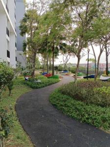a walkway in a park with trees and a building at Campus Convenience at Scientia Apartment in Tangerang