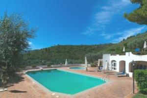 a swimming pool in front of a white house at ViSte in Porto Santo Stefano