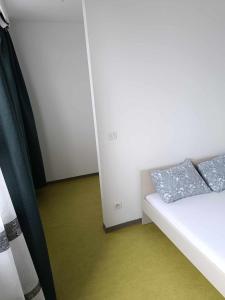 una camera con un letto bianco con due cuscini sopra di Chambre avec douche privé a Bruxelles