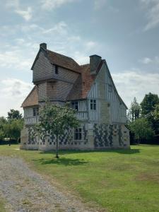 uma casa velha com uma árvore em frente em Le Léon em Honfleur