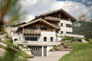 a large white house with a wooden roof at Luxury Chalet Plazola in Selva di Val Gardena
