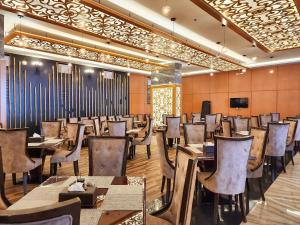 هوليداي الخليج الخبر Holiday Al Khaleej Hotel في الخبر: غرفة طعام مليئة بالطاولات والكراسي
