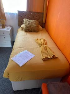 Una cama con dos toallas y un libro. en Quick Stop Night Stay - Gatwick, en Crawley