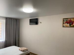 - une chambre avec un lit et une télévision murale dans l'établissement Двокімнатні апартаменти в ЖК Щасливий Запорізьке шосе 30, à Dnipro