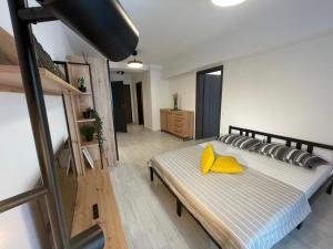 Un dormitorio con una cama con almohadas amarillas. en Moghioros Park Residence DUM3 en Bucarest