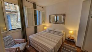 a bedroom with a bed and a mirror and a chair at Peppermint Bay in Skopelos Town