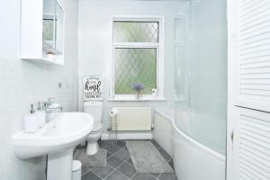 y baño blanco con lavabo, aseo y bañera. en Frilsham House by YourStays, en Stoke on Trent