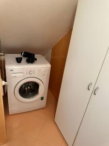 una lavatrice e asciugatrice in una piccola stanza di Conte Durini Apartments & Rooms ad Arcore