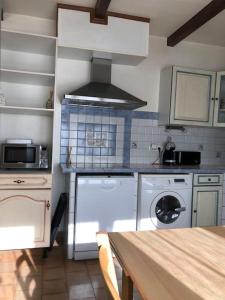 a kitchen with a stove top oven next to a washer at Studio Proche L'Isle sur Sorgue in Le Thor